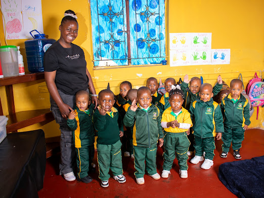 Teacher standing with a group of children in their classroom